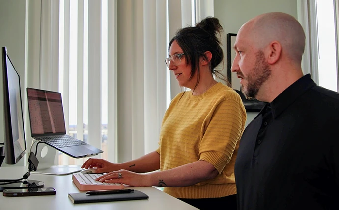 Two OuterBox SEO consultants collaborating at a workstation in the OuterBox office
