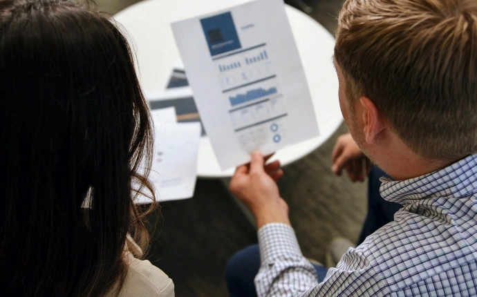 OuterBox link building agency team reviewing a printed performance report with bar charts and analytics graphs