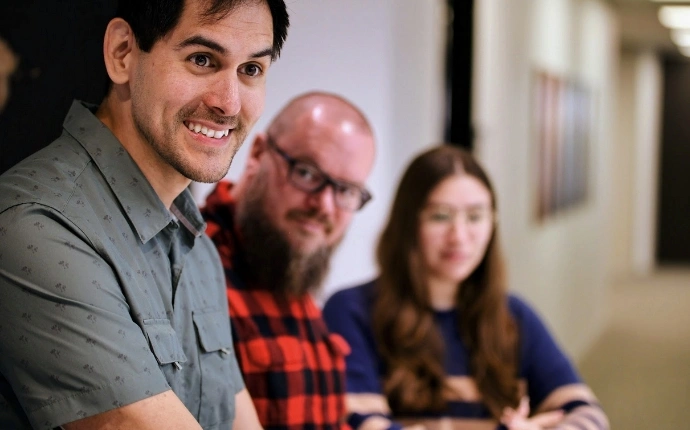 Three OuterBox team members standing together in casual business attire, the B2B digital marketing company behind the work.