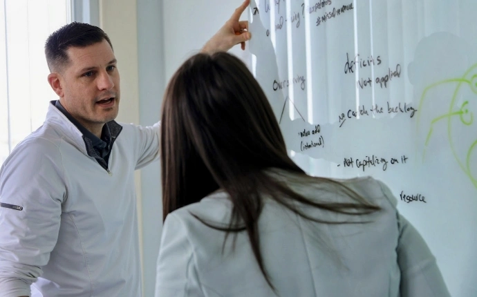 Two OuterBox employees reviewing a Google SEO strategy on a whiteboard.