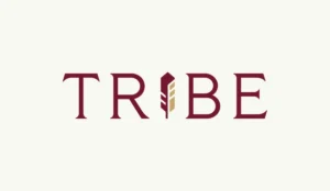 The Tribe Tallahassee student-housing community official TRIBE wordmark with its gold feather monogram on the brand's cream backdrop