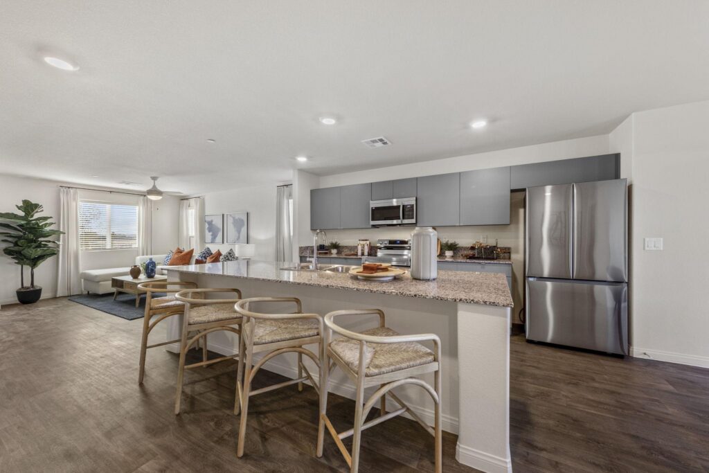 Touchstone Living Mosaic model-home kitchen and great room with granite island and stainless appliances