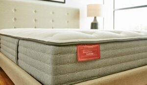 Ortho Mattress bed with its red product label in a bedroom