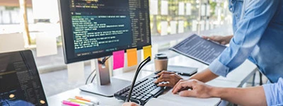 SEO consulting specialist reviewing website performance data on desktop monitors