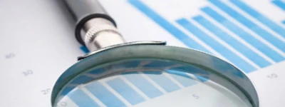 Magnifying glass over performance charts representing healthcare SEO analysis and search visibility